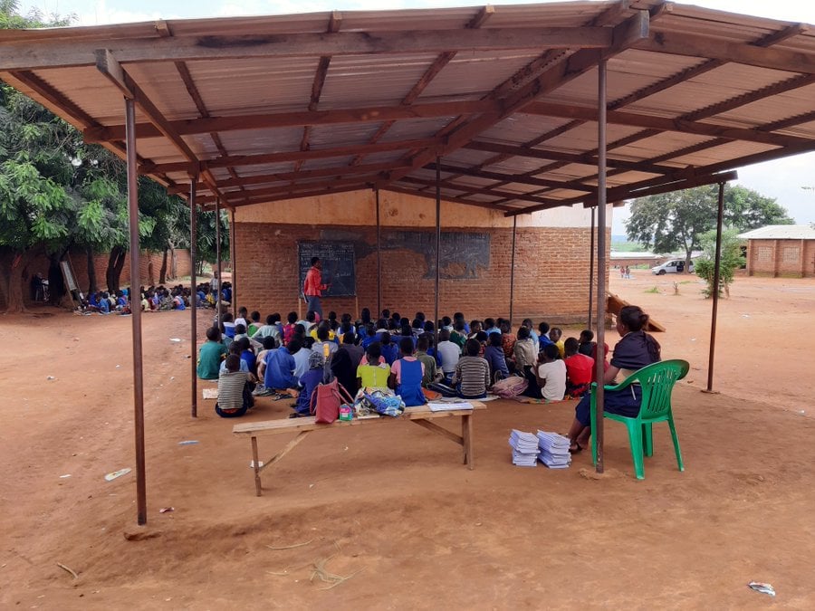 Open classroom with children and teachers actively engaged in day-to-day activities, promoting community building during the Malawi Study Visit