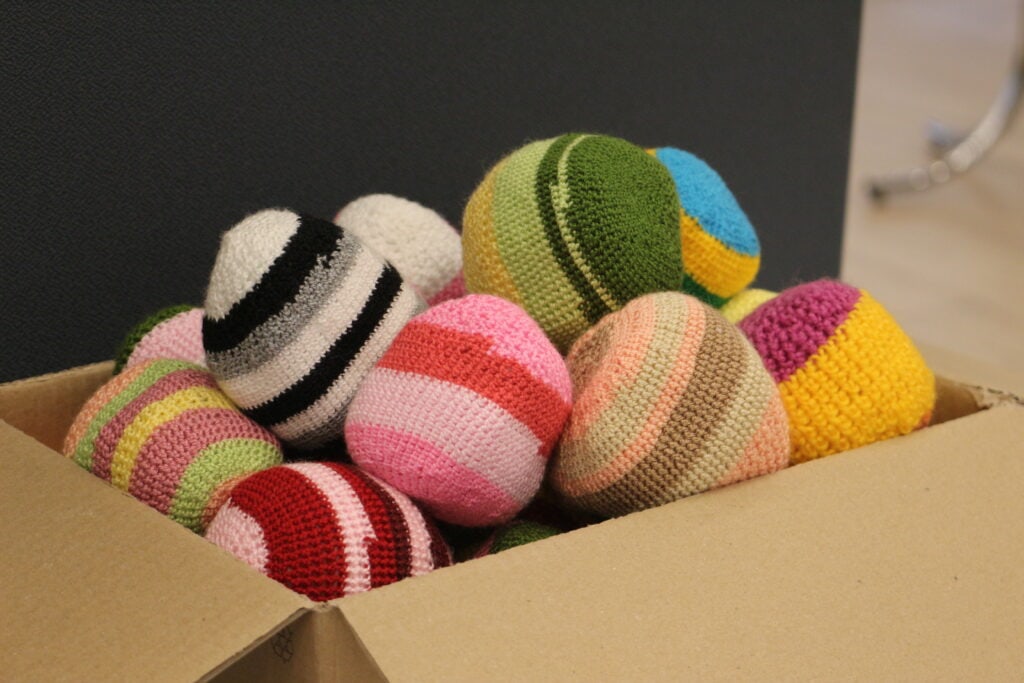 Close-up of colourful hand-knit anti-stress balls at BioBeo Festival