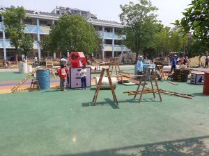 A larger Anji playground with diverse materials, including sand, water, and climbing structures, enabling inclusive and creative play